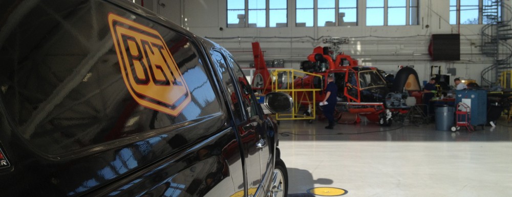 A Black Gold Industries pickup truck parked in an aircraft hangar.