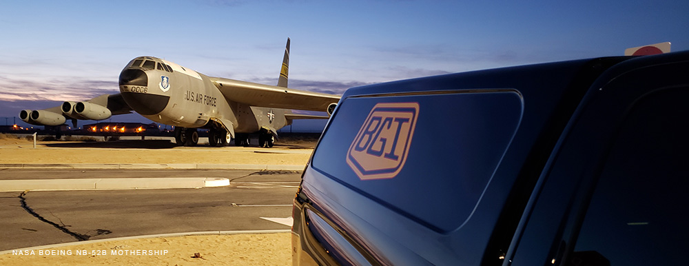 A Black Gold Industries pickup truck parked in front of a NASA Boeing NB52 mothership aircraft.